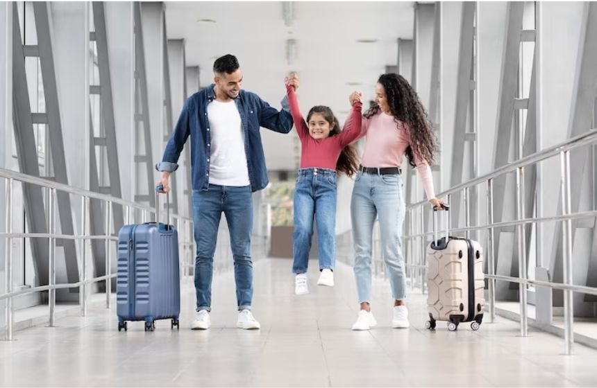 happy family in airport with luggage moving to france