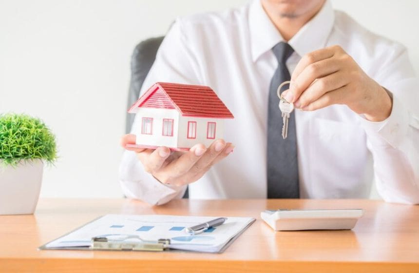 a man in suit giving home and key